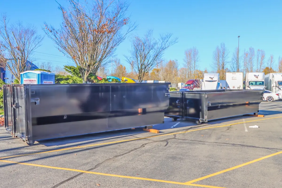 Professional dumpster rental service with roll-off container on residential driveway in Roma